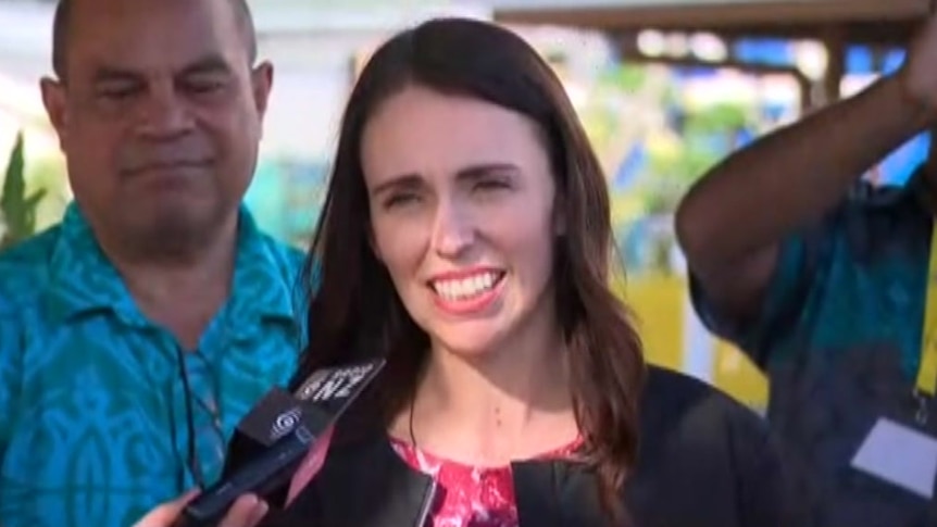 Jacinda Ardern speaks into a microphone