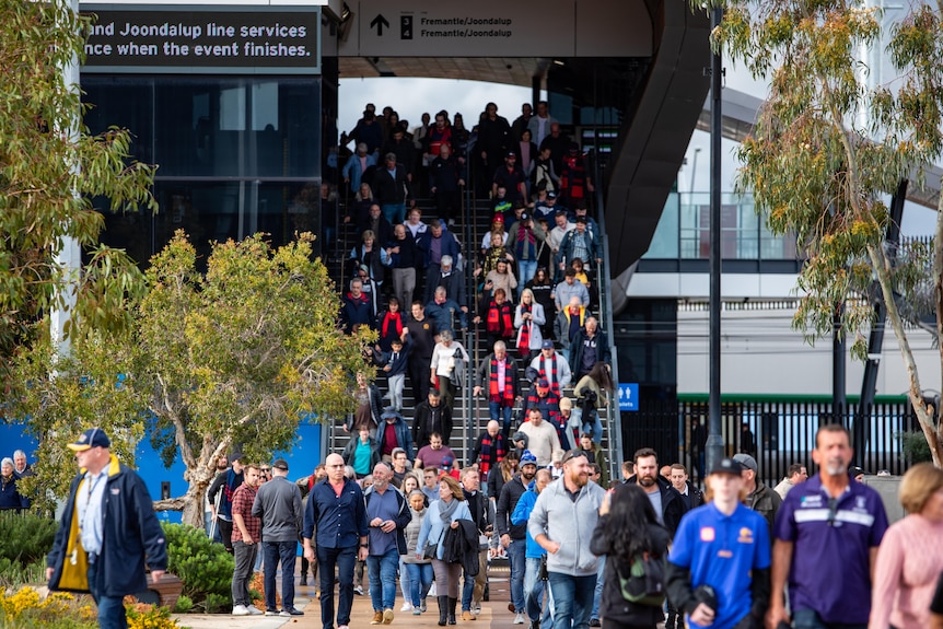 A crowd descending the stairs of Perth Stadium Station.