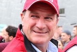 A middle-aged man in a bright-coloured cap and matching jacket.