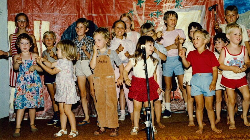 Children performing on a stage in the 1980s