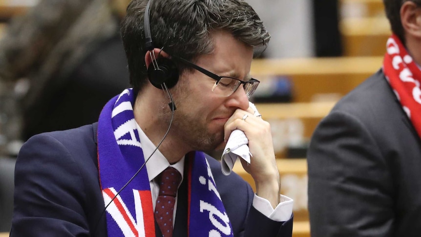 An MEP wearing a scarf looking emotional during the EU Parliament vote in Brussels.