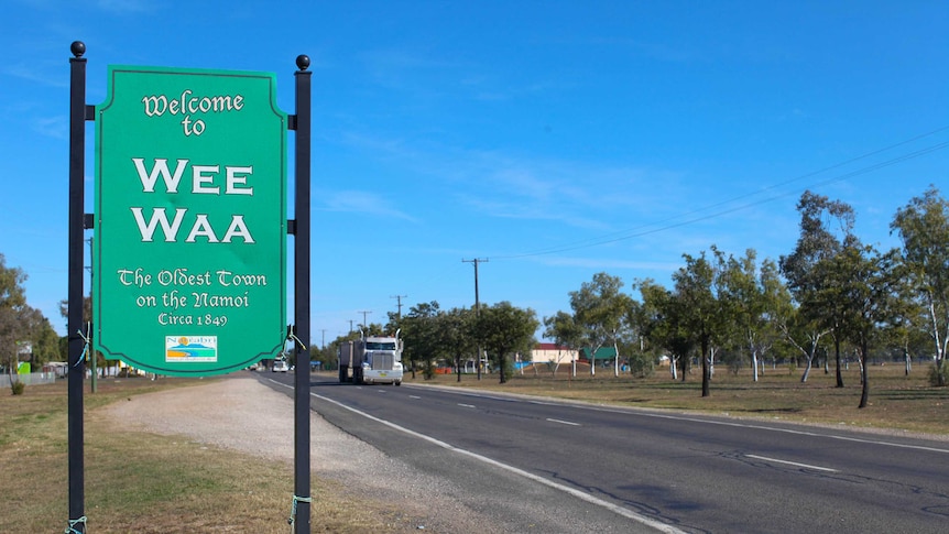 Welcome to Wee Waa sign on towns main road with a truck in the distance
