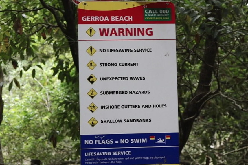 A warning sign among the trees reads: "NO LIFESAVING SERVICE" and other messages in capital letters.