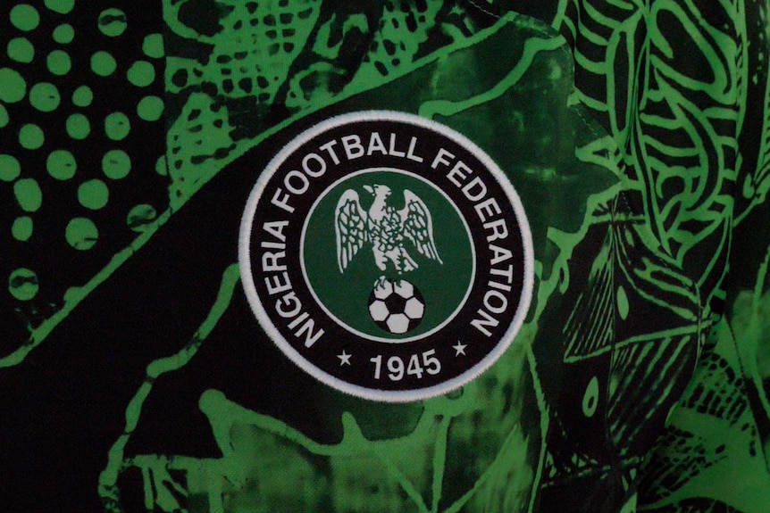 A closeup of the Nigerian Football Federation logo on a green playing shirt.