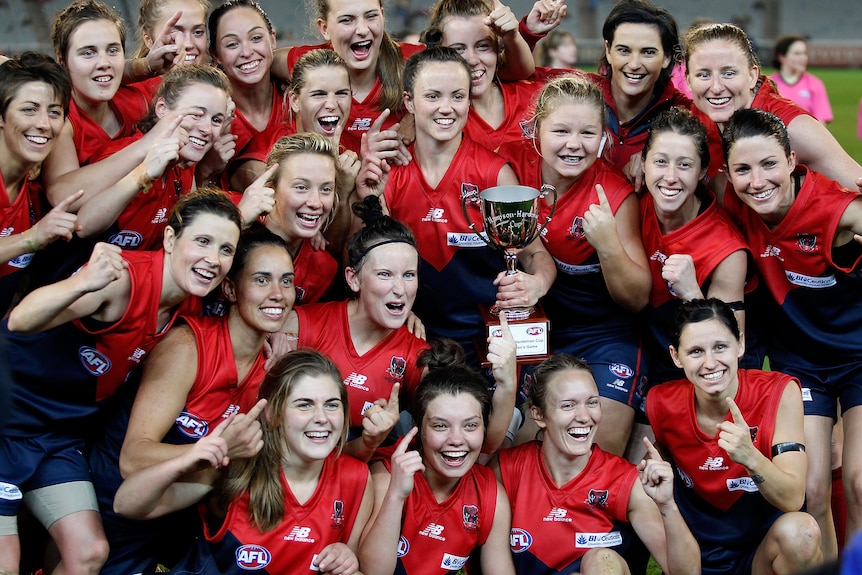 Players representing the Demons in 2013 - including captain Daisy Pearce - celebrate a win
