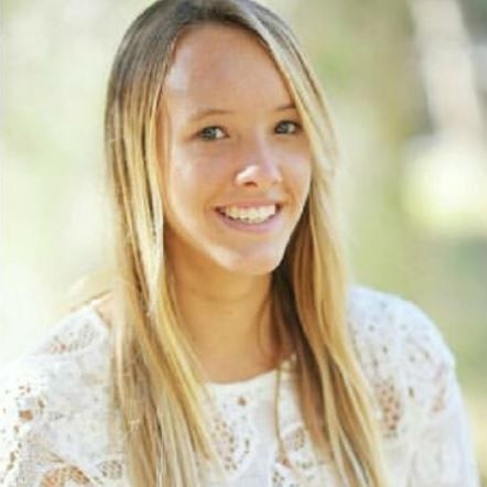 A profile shot of a smiling teenage girl with long blond hair.