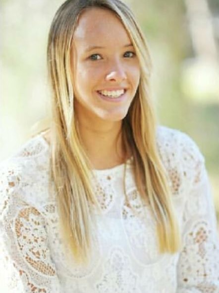 A profile shot of a smiling teenage girl with long blond hair.