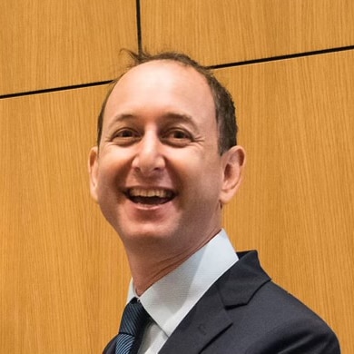 A man in a suit smiling.