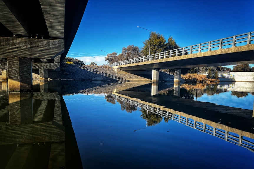 A pond with two road bridges going over it.