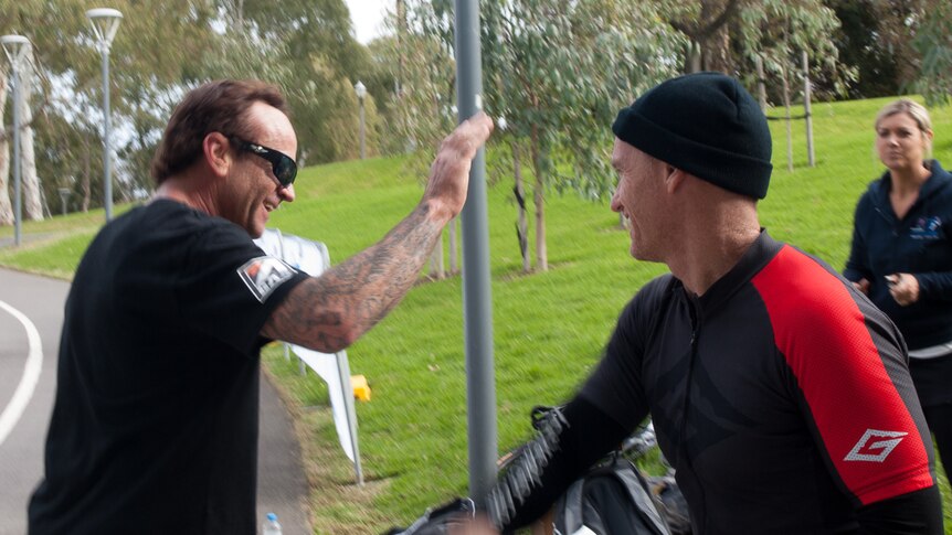 Mentor and ex-Ironman Guy Andrews high-fives Ian Harvey at Adelaide finish line.