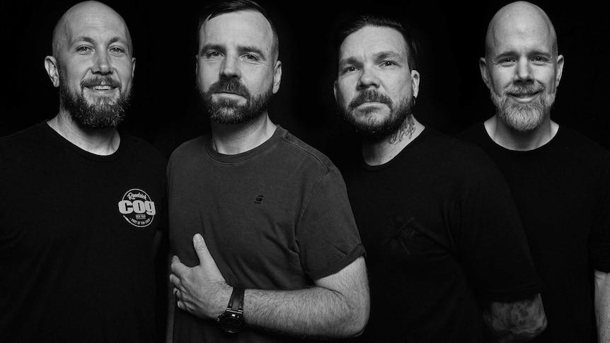 Photo of heavy rock band The Butterfly Effect. Four men with beards. Two are bald. Staring at camera in black and white.