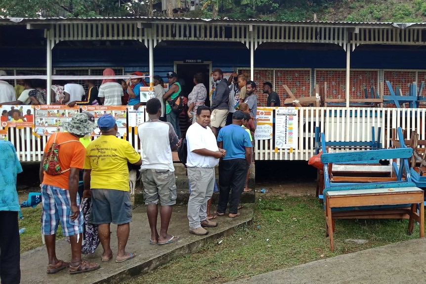 A long line of voters queue to cast their vote.