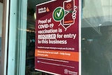 A sign reading "proof of COVID-19 vaccination is required for entry to this business'
