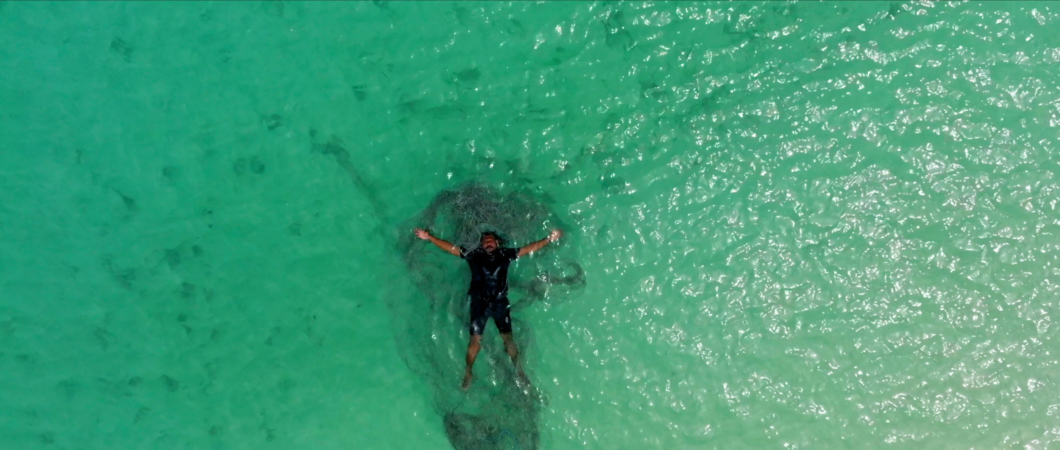 An image of a man lying in a pool of green water