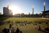 A wide shot of the WACA Ground with spectators sitting on grass watching a ODI between Australia and South Africa under the sun.