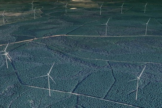 looking from high above at wind turbines dotted throughout the forest