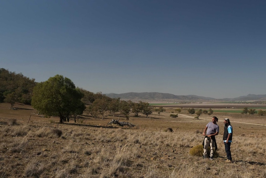 Steve Talbott (r) pictured on the Shenhua mining lease, looking up a hill.