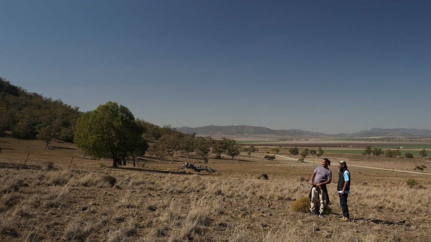 Steve Talbott (r) pictured on the Shenhua mining lease, looking up a hill.