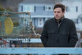 Casey Affleck in the movie Manchester by the Sea standing on a pier