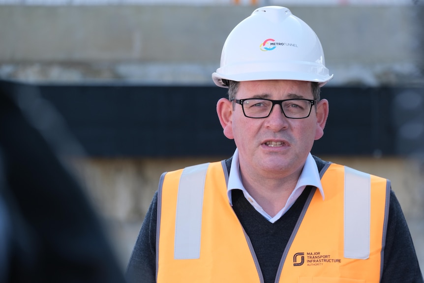 Daniel Andrews wearing a white hardhat and an orange fluro vest.