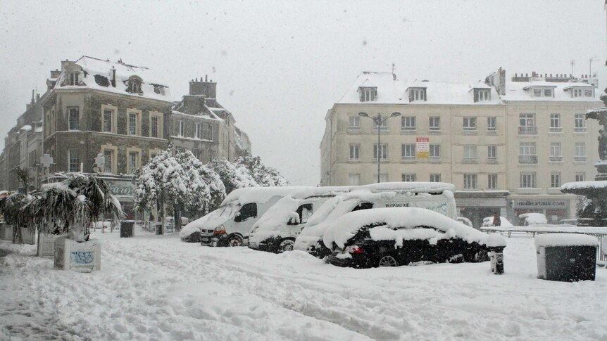 Snow covers vehicles parked in the French city of Cherbourg.