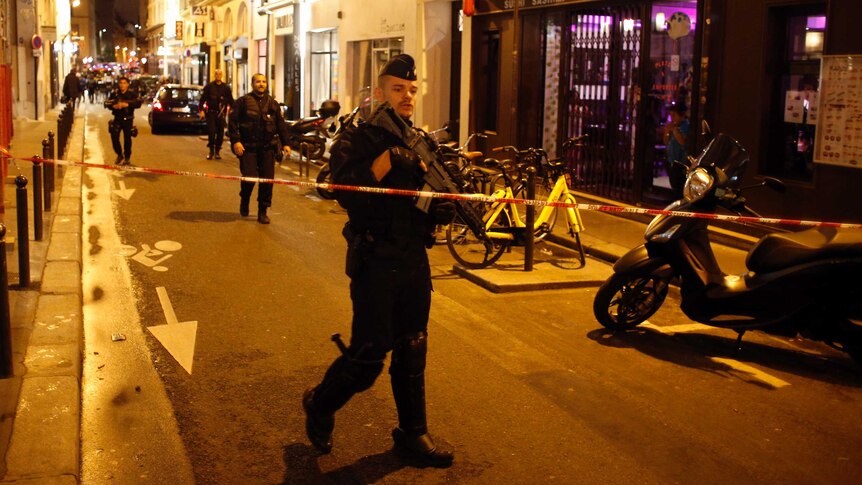 A police officer cordons off the area after a knife attack in central Paris.