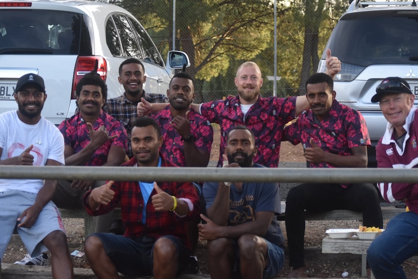 a group of rugby players smiling together after a match
