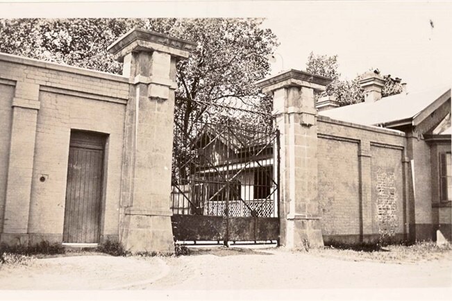 A black and white photo of a large gate.