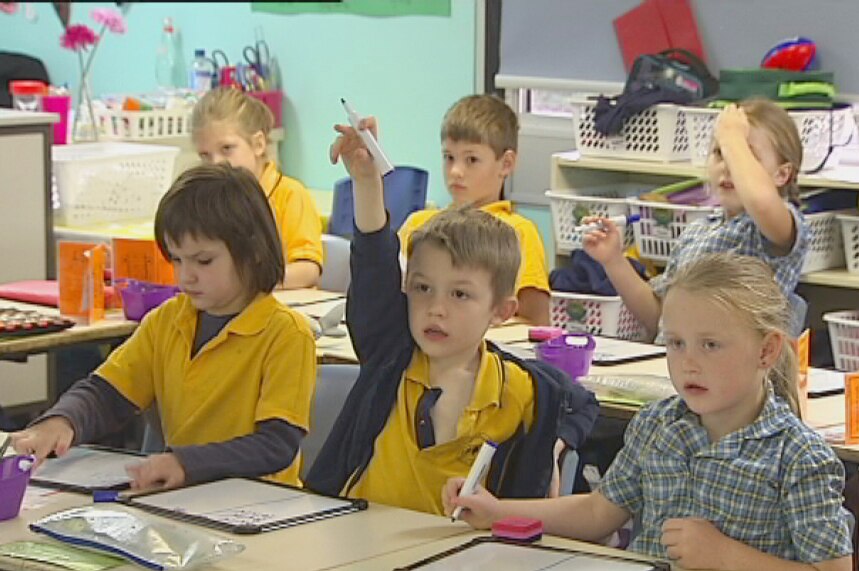 A student at Challis puts his hand up as primary students listen in class