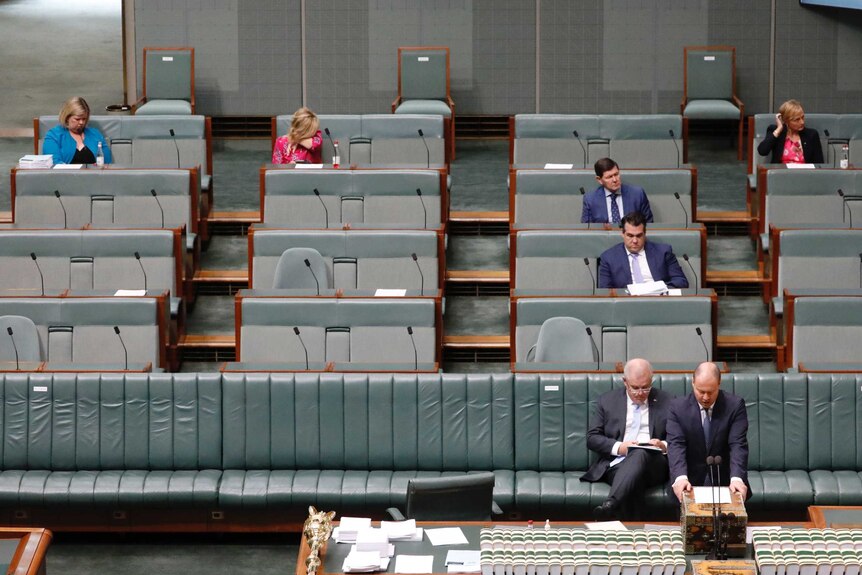 Six members sit in separate benches more than a metre away from each other in the House of Representatives.