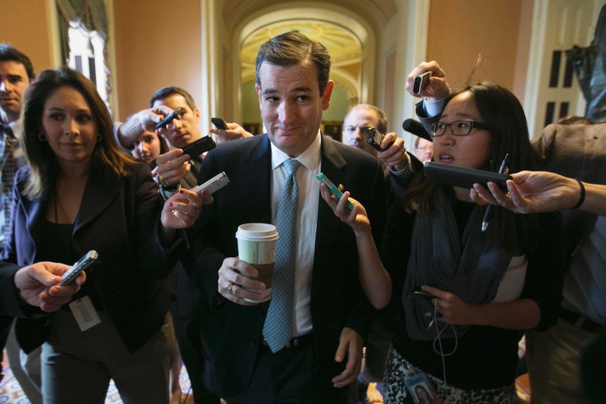 Senator Ted Cruz is trailed by reporters.