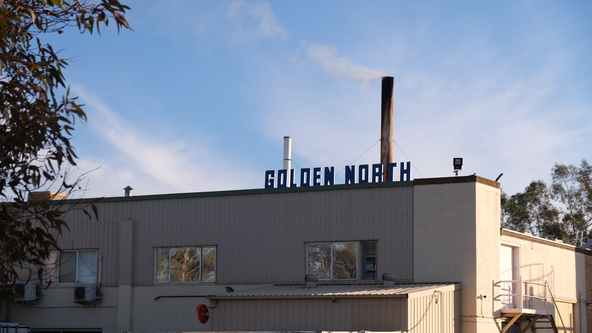Una fábrica blanca con el nombre Golden North sentado sobre letras azules.