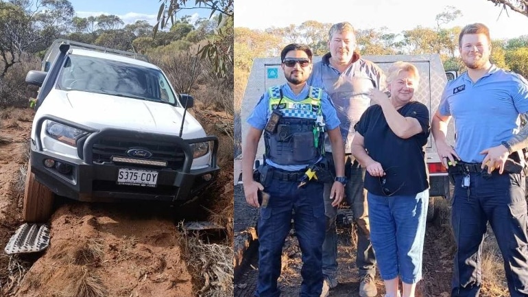 white car bogged in mud and four people - three men and one woman pose form a photo in scrubland