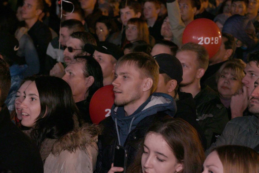 Supports smile as they listen to Alexei Navalny speak at the rally.