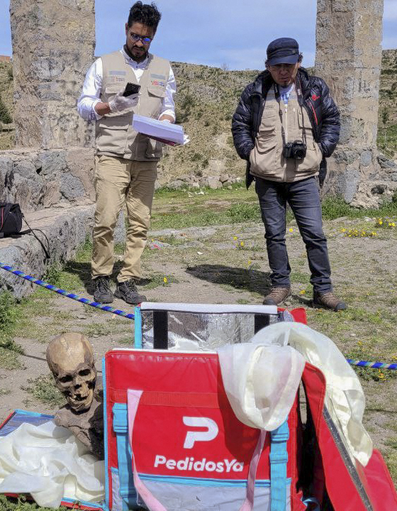 Two men inspect the remains of a mummy found inside a cooler box
