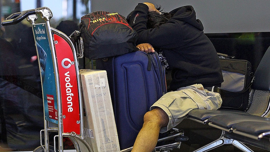 A Qantas passenger rests on a luggage trolley at Perth's international terminal on October 29, 2011.