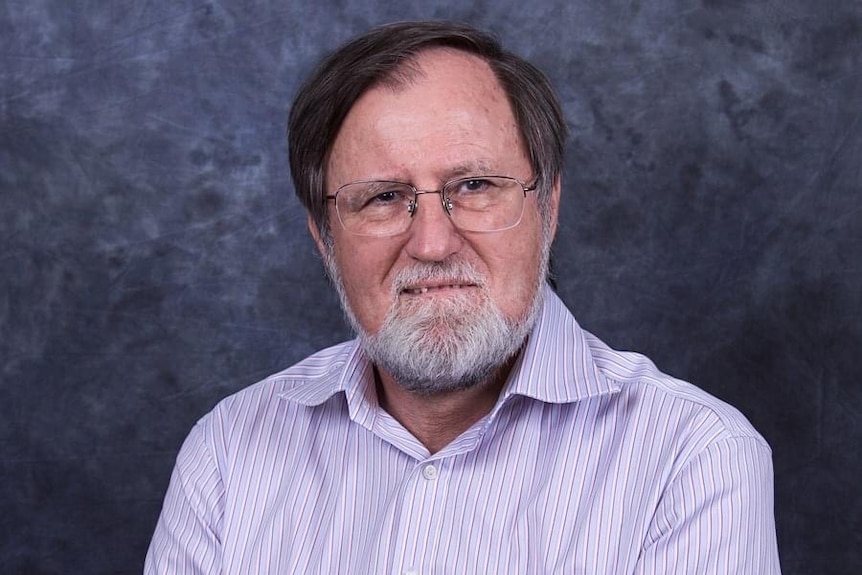 A profile photo of a bearded man in glasses.