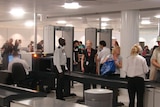Passengers pass through an security screening check-point at Brisbane international airport