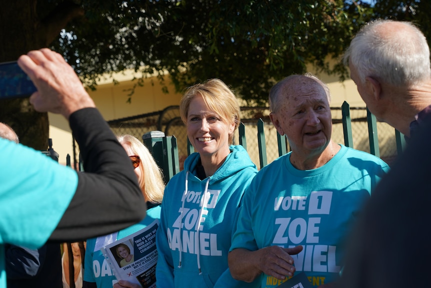 Goldstein candidate Zoe Daniel is surrounded by supporters on election day. She is wearing a teal hoodie