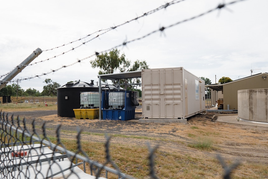 A mobile desalination plant behind a fence.
