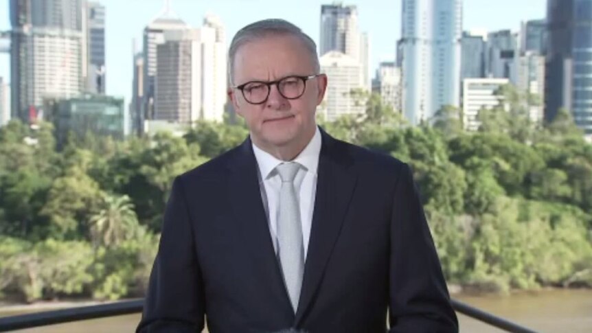 Anthony Albanese, in a suit and white tie, faces the camera.