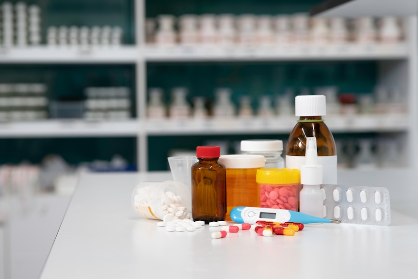 pills, tablets, and nasal spray are seen on the counter of a dispensary.