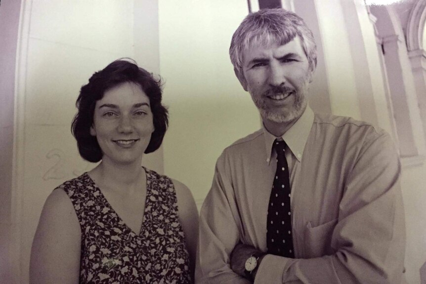 A man and a woman outside a building in black and white.