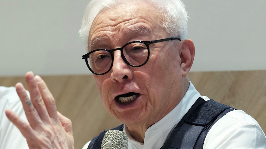 Robert Tsao speaks while wearing body armour during a press conference