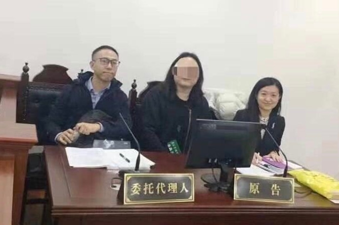 Three people sit at a court bench