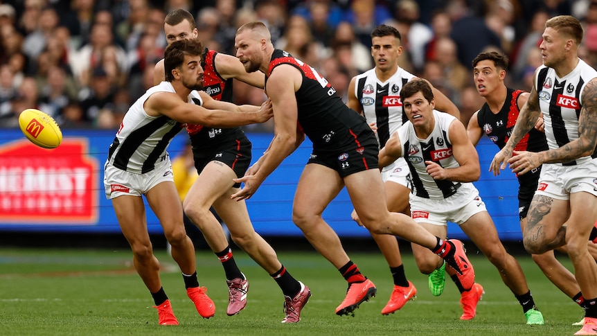 Jake Stringer handballs under pressure from Josh Daicos