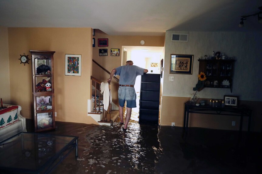 A man stands in flood water in his living room in Houston.