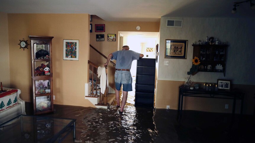A man stands in flood water in his living room in Houston.
