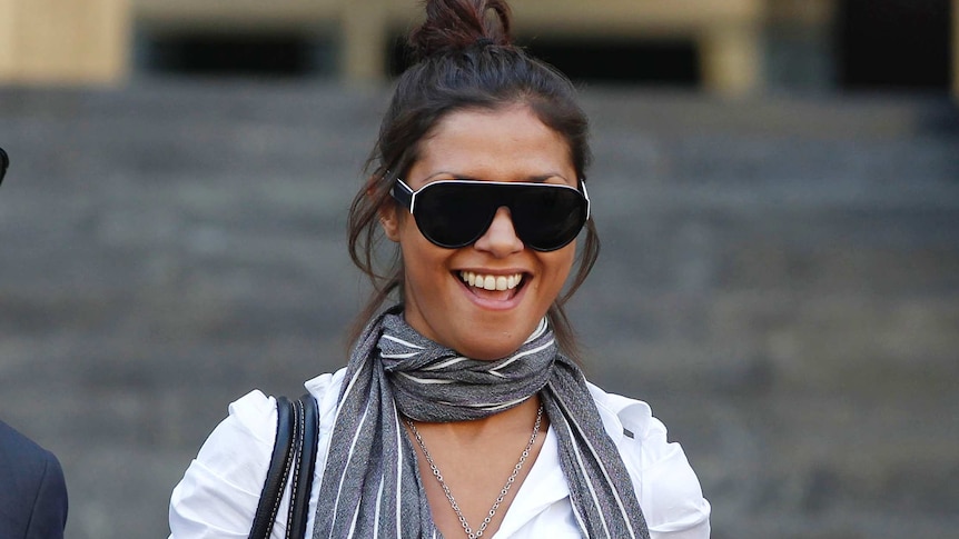 Imane Fadil smiles as she is photographed with her brown hair tied in a high ponytail and large glasses on.