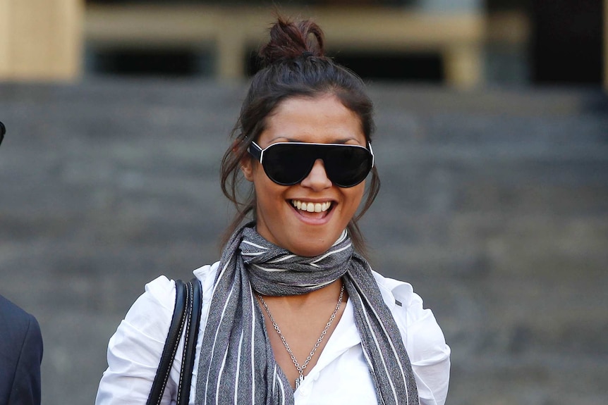 Imane Fadil smiles as she is photographed with her brown hair tied in a high ponytail and large glasses on.
